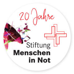 Man sieht das Logo der Stiftung Menschen in Not (ein stilisiertes rotes Kreuz). Darüber der Text 